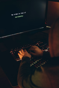 Photo of a hacker typing on a keyboard working at a desk cybersecurity